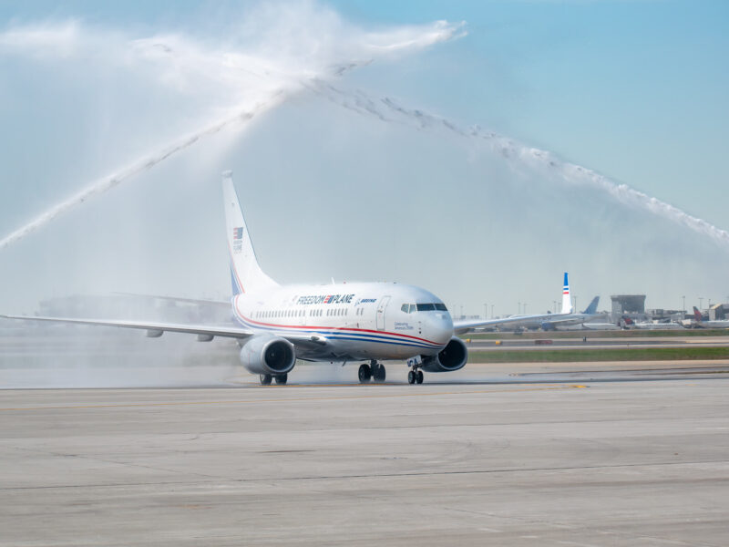 The Freedom Plane on the tarmac with sprays of water from either side.